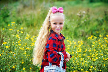 Portrait of a little girl with long hair in nature