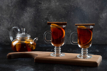 Two glass cups with hot tea and cinnamon sticks