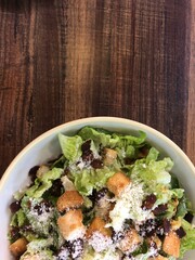 Caesar Salad with plain wood table cooking backgorund