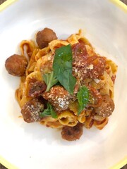Italian cuisine pasta and meatballs with basil and cheese