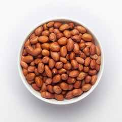 organic red brown peanuts (Arachis hypogaea) in white Ceramic bowl, Top View
