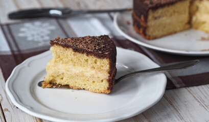 Freshly baked sponge cake Enchantress, covered with icing with grated chocolate.