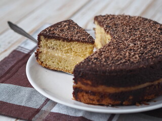 Freshly baked sponge cake Enchantress, covered with icing with grated chocolate.
