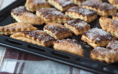 Freshly baked biscuits sprinkled with cinnamon and sugar on a baking sheet from the kitchen oven.Home cooking.