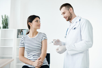 male doctor in the hospital makes an injection in the patient's arm vaccination