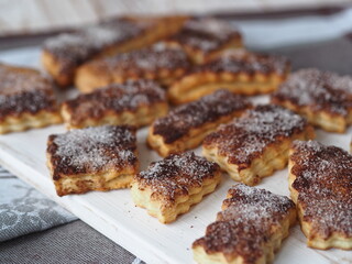Butter biscuits sprinkled with cinnamon and sugar on a kitchen cutting board. Home cooking.