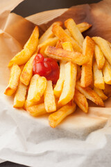 Home made oven baked french fries on kitchen paper. Fast, unhealthy food.