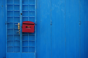 Red old letter box on blue wooden wall