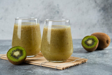 A glass cup of delicious kiwi juice on a wooden board