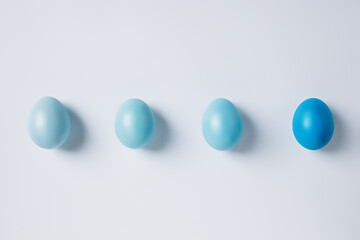 Painted Easter eggs in blue gradient on bright white background. Minimal spring holiday or food concept. Flat lay, top view.