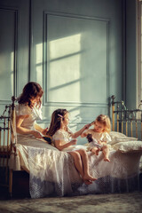 Мама с дочками на кровати