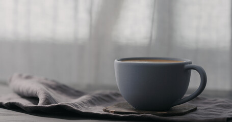 Slow motion cappuccino in blue cup on black wood table