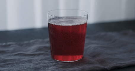 pink drink in tumbler glass on black wood table with copy space
