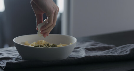 put mozzarella on fettuccine in white bowl on linen cloth