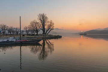 Sunrise over a misty riverside