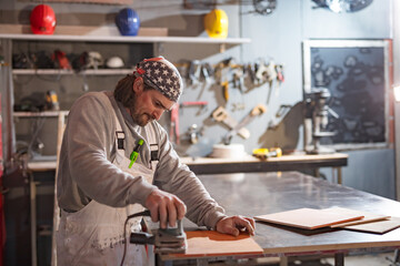 Male carpenter working on old wood in a retro vintage workshop.