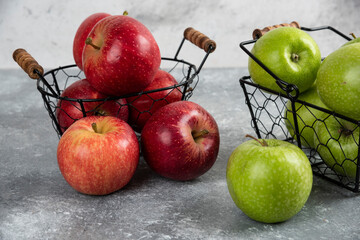 Pile of fresh green and red apples placed in metal baskets