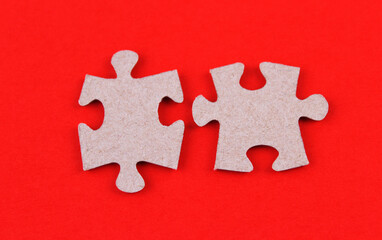 Two pieces from a puzzle on a red background