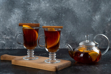 Two glass cups with delicious tea and cinnamon sticks