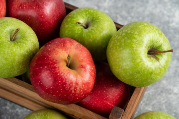 Fresh delicious green and red apples in wooden box