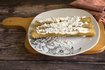 Tacos dorados called flautas with cream and cheese. Traditional Mexican food