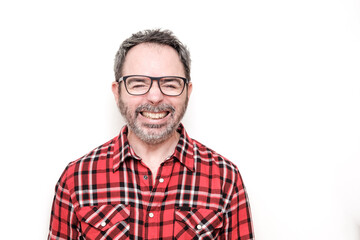 Obraz premium Portrait of a laughing mature man with bear wearing red plaid shirt and glasses.