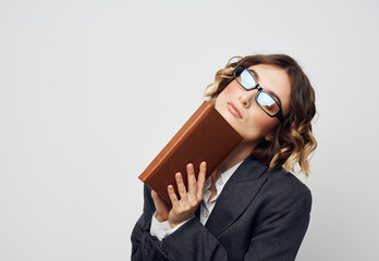 Business woman in a classic suit with a book in her hands and glasses on her face