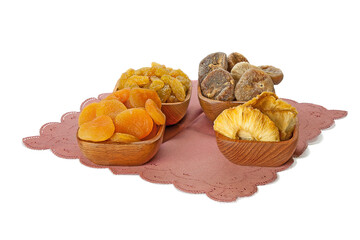 Dried pineapple, apricot, fig, raisins in the bowls оn a napkin isolated on white