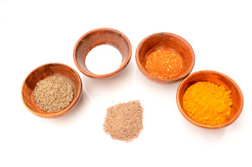 decorative with wooden bowl in the salt,cuisine,cumin,chilly powder, turmeric, on the white background.