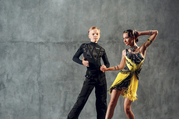 Young couple dancers dancing ballroom dance cha-cha-cha.