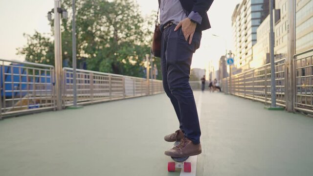 Young Adult Working Man In Business Attire Suit, Get On The Skateboard Transportation To Work Office, Urban City Lifestyle Avoid From Crowded Traffic Jam, Morning Sun Light, Modern Active Lifestyle 