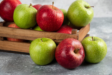 Fresh delicious green and red apples in wooden box
