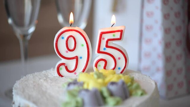 Birthday candle as number ninety five 95 on top of sweet cake on the table, 95th birthday, HD