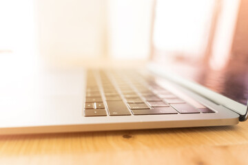 Modern laptop on a wooden table. Computer keyboard closeup