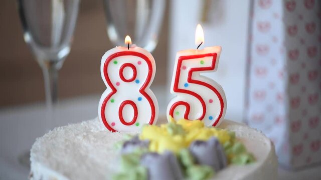 Birthday candle as number eighty five 85 on top of sweet cake on the table, 85th birthday, HD	