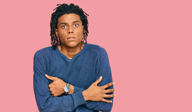 Young african american man wearing casual winter sweater shaking and freezing for winter cold with sad and shock expression on face
