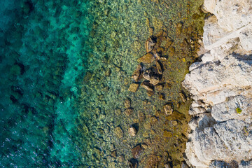 Top view of rocky coastline with turquoise water.