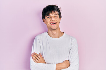 Obraz premium Handsome hipster young man wearing casual white shirt happy face smiling with crossed arms looking at the camera. positive person.