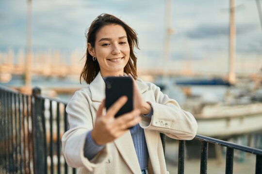 Young hispanic woman smiling happy doing video call using smartphone at the city.
