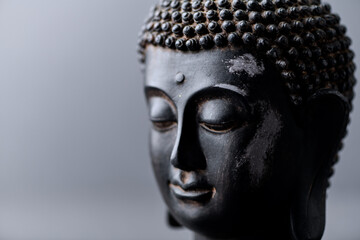 Meditating Buddha on gray background. Soft focus. Close up. Copy space. 