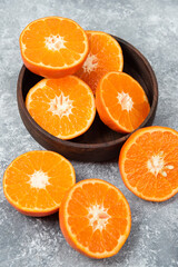 Sliced juicy fresh orange fruits in a wooden bowl