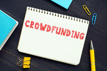 Business concept meaning CROWDFUNDING with sign on the page. The use of small amounts of capital...