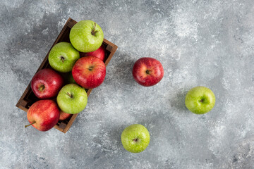 Whole green apples and cinnamon sticks on marble background