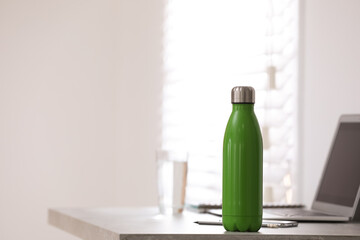 Thermo bottle on table in modern office
