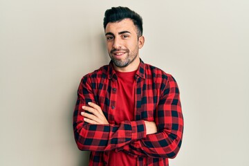 Young hispanic man wearing casual clothes happy face smiling with crossed arms looking at the camera. positive person.