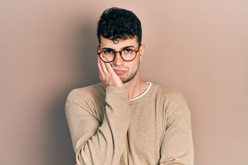 Young hispanic man wearing casual clothes and glasses thinking looking tired and bored with depression problems with crossed arms.
