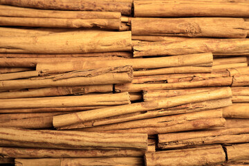Aromatic dry cinnamon sticks as background, closeup
