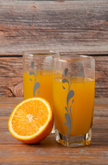 Orange juice in a glass cup with sliced fruit around
