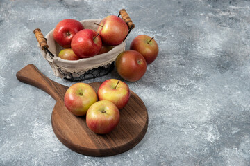 Pile of fresh ripe apples on wooden board and in basket