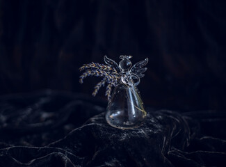 miniature decorative vase on black background, bottle vase in the shape of an angel with dry lavender, cute glass vase with lavender flowers, glass angel with wings